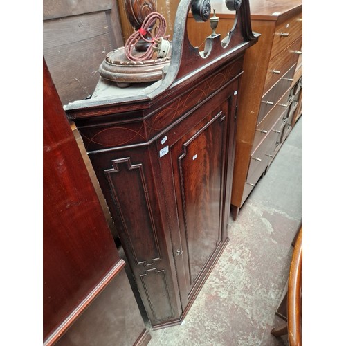 914 - A George III inlaid mahogany corner cupboard.