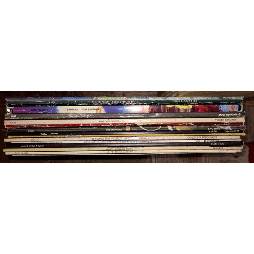 121 - Sixteen vinyl LP records including Santana, Phil Collins, The Pogues, Wings, etc.