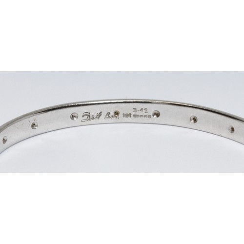 3 - DAVID BURNS: an 18ct white gold diamond bangle, sixteen round brilliant cut diamonds weighing approx... 