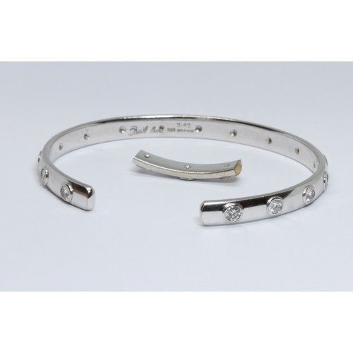 3 - DAVID BURNS: an 18ct white gold diamond bangle, sixteen round brilliant cut diamonds weighing approx... 