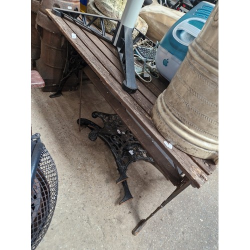 22 - A garden table and a pair of cast metal bench ends