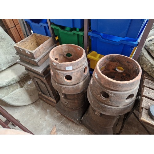 20 - A pair of terracotta chimney pots and one other.