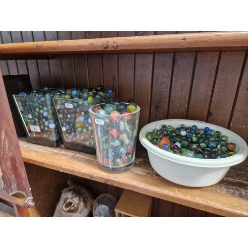 47 - A quantity of vintage glass marbles in glass vases and a tub.