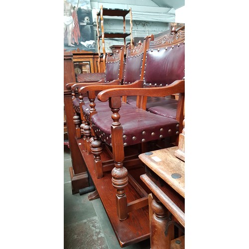 905 - An oak refectory table and six studded oak and leather dining chairs.