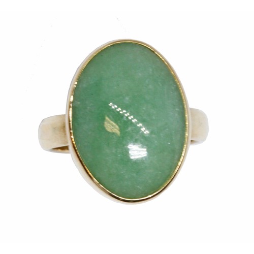 61 - A jadeite jade cabochon ring, the bezel set cabochon measuring approximately 15mm x 6mm, yellow band... 