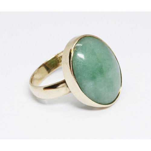 61 - A jadeite jade cabochon ring, the bezel set cabochon measuring approximately 15mm x 6mm, yellow band... 