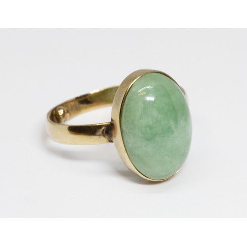 60 - A jadeite jade cabochon ring, the bezel set cabochon measuring approximately 16mm x 6mm, yellow band... 