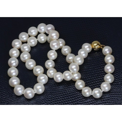 45 - A cultured pearl necklace, the white pearls approximately 9mm to 10mm in diameter, diamond set spher... 