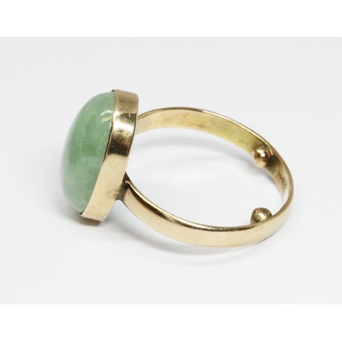 60 - A jadeite jade cabochon ring, the bezel set cabochon measuring approximately 16mm x 6mm, yellow band... 