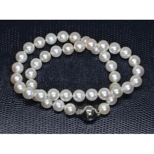 46 - A cultured pearl necklace, the white pearls approximately 9mm in diameter, with white metal spherica... 