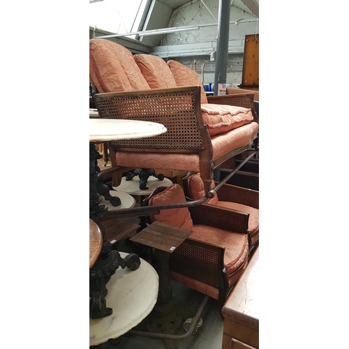 986 - A 1920s/1930s Bergere sofa and two matching armchairs.