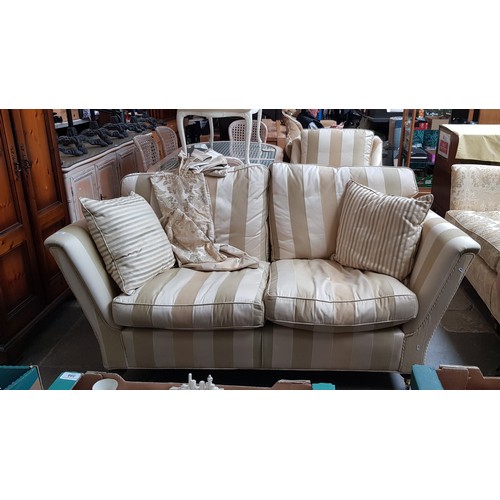 1004 - A Duresta cream and gold two seater sofa and matching armchair.