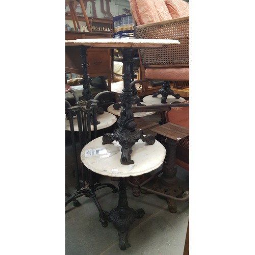 992 - A pair of cast iron and marble top tables, height 72cm & diameter 61cm.