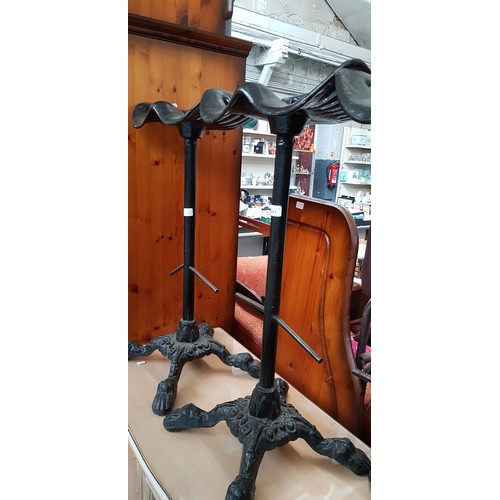 1001 - A pair of cast iron tractor seat bar stools, height 82cm (overall).