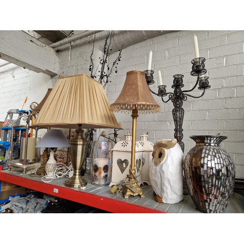 221 - A large collection of table lamps and candle holders, a wooden carved owl and a vase