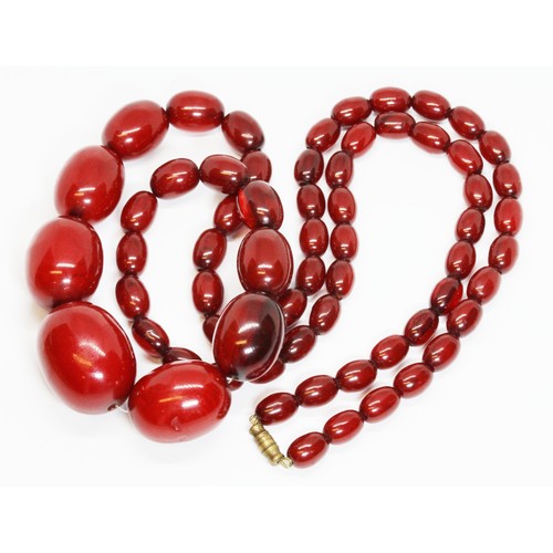 71 - A single strand of graduated marbled cherry bakelite beads, the oval shaped beads ranging in length ... 