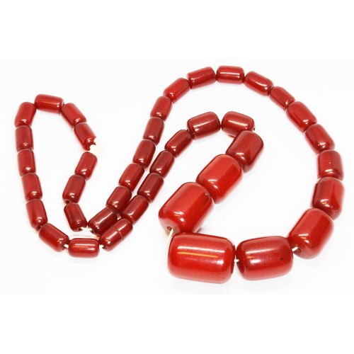 70 - A single strand of graduated barrel shaped and marbled cherry bakelite beads, the beads ranging in l... 