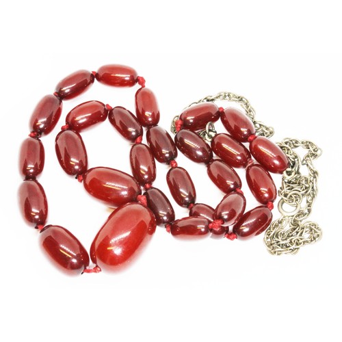 72 - A single strand graduated marbled cherry bakelite beads, the oval beads ranging in length from 13mm ... 