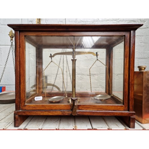 115B - A set of scales in wood & glass display case.