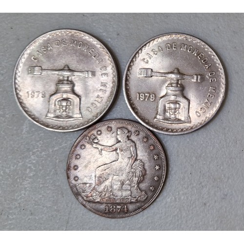 284 - Two 1979 Mexican 1 onza silver bullion coins and a replica trade dollar.