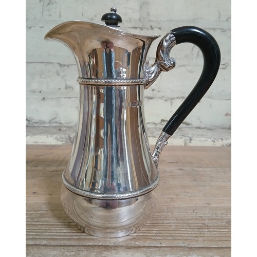 215 - A hallmarked silver hot water jug, height 18.5cm, gross weight 18ozt.