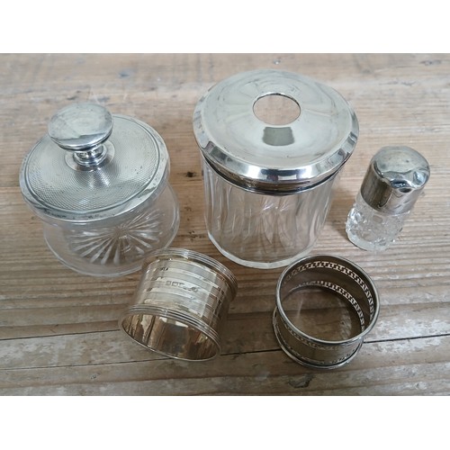 211 - Hallmarked silver comprising two serviette rings, a scent bottle and two silver topped jars.