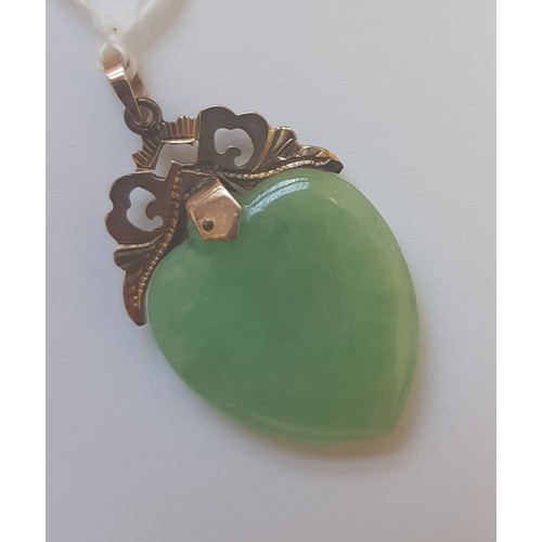 74 - A jadeite jade heart shaped double sided cabochon pendant, yellow metal mount, the bail marked '585'... 