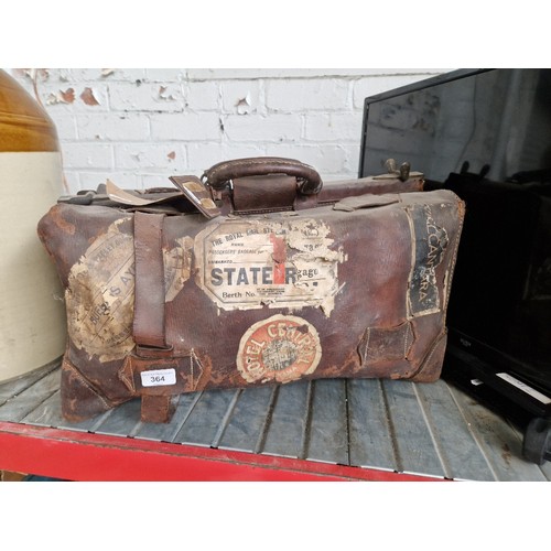 364 - A vintage leather travel bag with various old travel labels.