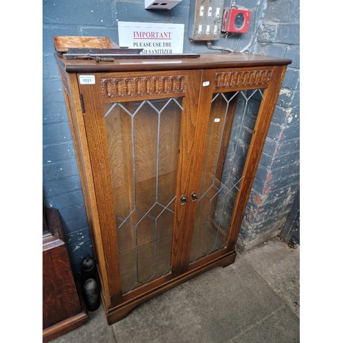 1021 - An oak and leaded glass display cabinet.