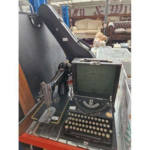 293 - Assorted items comprising a student's violin, a vintage typewriter and a Singer sewing machine.