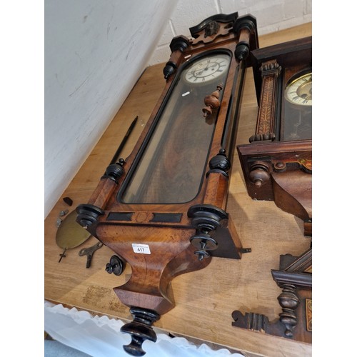 417 - A Walnut and ebonised cased Vienna wall clock with weights pendulum and key.