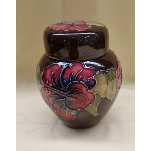 455 - Ginger jar, with lid, by Moorcroft, hibiscus pattern on brown ground. Height 11cm