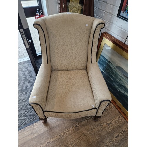 1022 - An Edwardian wingback armchair.