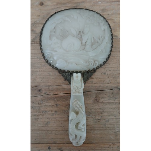 74 - An early 20th century Chinese carved jade and gilt metal mounted hand mirror, the 18th/19th century ... 