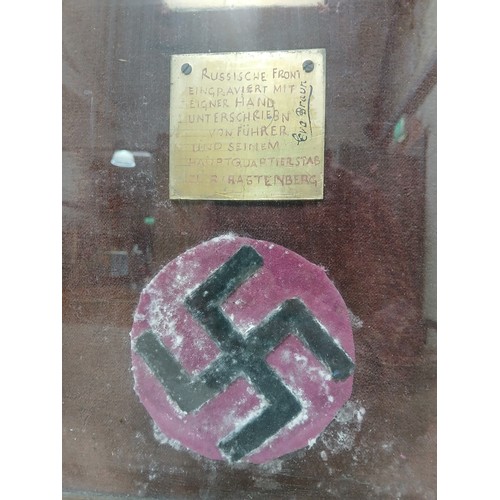 52 - A frame felt swastika and brass plaques bearing the signatures of Adolf Hitler (1889-1945), chief of... 