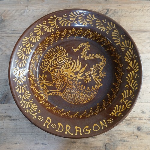 94 - A large Wetherigg Penrith slipware terracotta with decoration in yellow titled 'A Dragon', diameter ... 