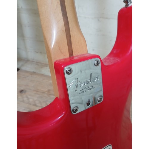 134 - A Fender Stratocaster electric guitar, made in the USA, red with white pick guard, maple neck, seria... 