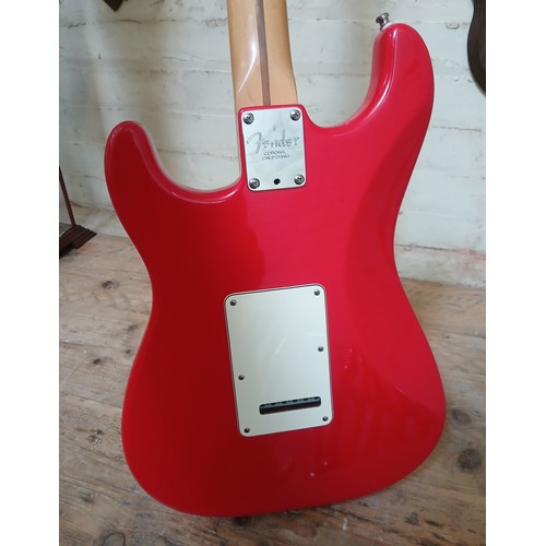 134 - A Fender Stratocaster electric guitar, made in the USA, red with white pick guard, maple neck, seria... 