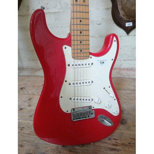 134 - A Fender Stratocaster electric guitar, made in the USA, red with white pick guard, maple neck, seria... 