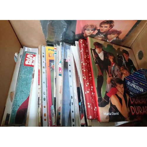 372 - A box of Duran Duran related memorabilia including magazines, books, one record, various badges etc