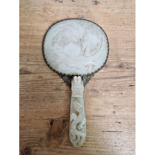 74 - An early 20th century Chinese carved jade and gilt metal mounted hand mirror, the 18th/19th century ... 