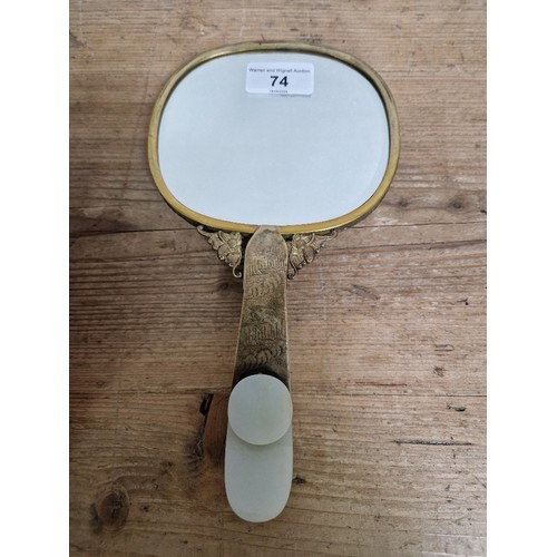 74 - An early 20th century Chinese carved jade and gilt metal mounted hand mirror, the 18th/19th century ... 