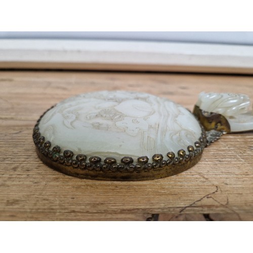 74 - An early 20th century Chinese carved jade and gilt metal mounted hand mirror, the 18th/19th century ... 