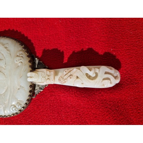 74 - An early 20th century Chinese carved jade and gilt metal mounted hand mirror, the 18th/19th century ... 