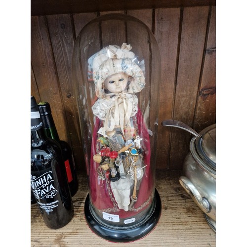 19 - A vintage Peddler doll with wax head holding a variety of wares, displayed in glass dome.