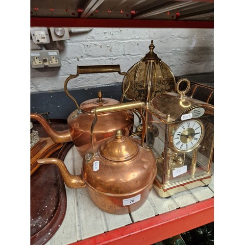 78 - Two copper kettles, a mantle clock & a table lamp.