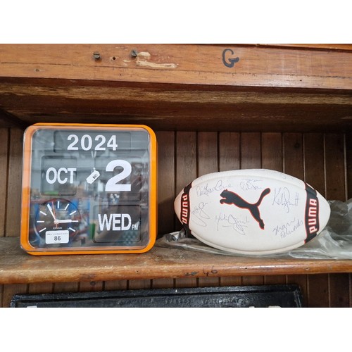 86 - A battery operated auto Calendar Quartz clock together with a signed Wigan Rugby league ball, signat... 