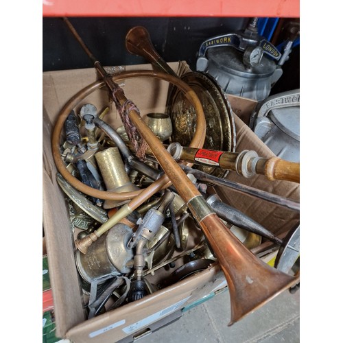 83 - A box of assorted metalware to include brass chargers, brass blow lamps, copper horns, weights & cup... 