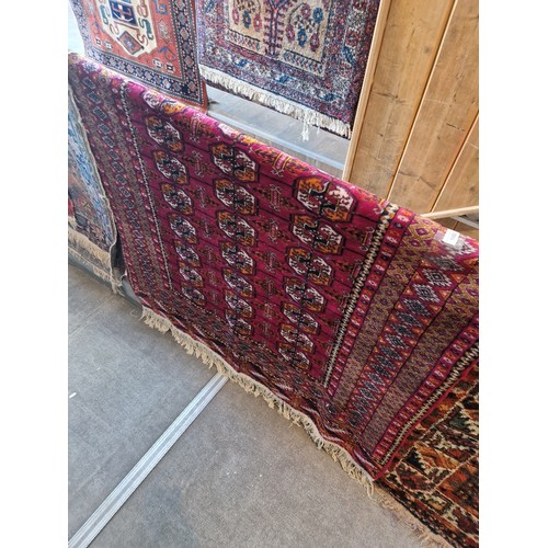 1002 - A Middle Eastern Bokhara style silk carpet, red ground, 210cmx 130cm (approx)