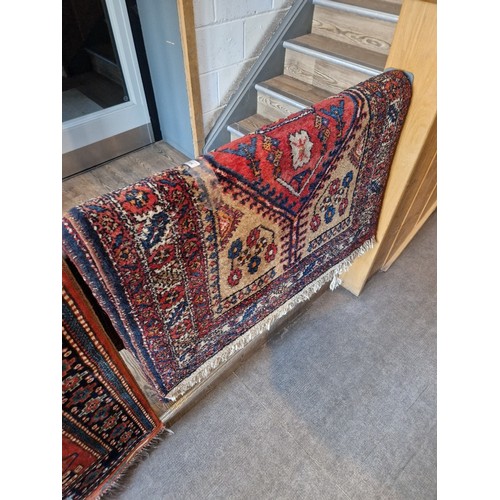 1004 - A Eastern wool runner, red ground with geometric design, 450cm x 104cm (approx).